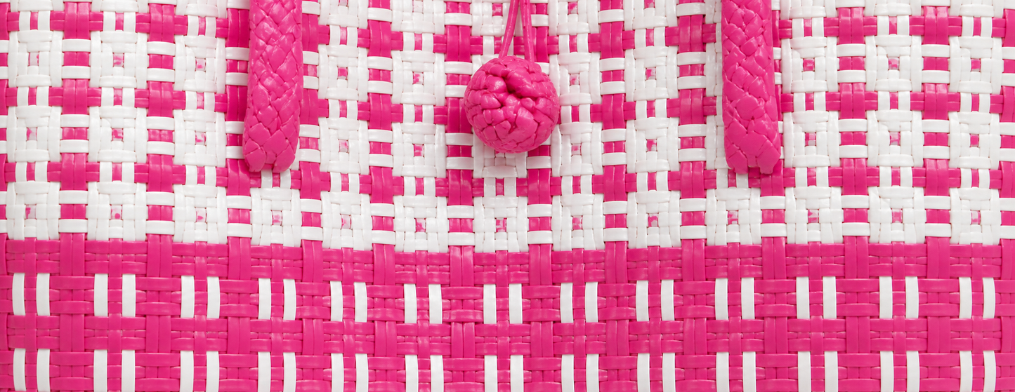Close-up of the Classic Flamingo Gala Bag, a pink and white woven bag with decorative knots.